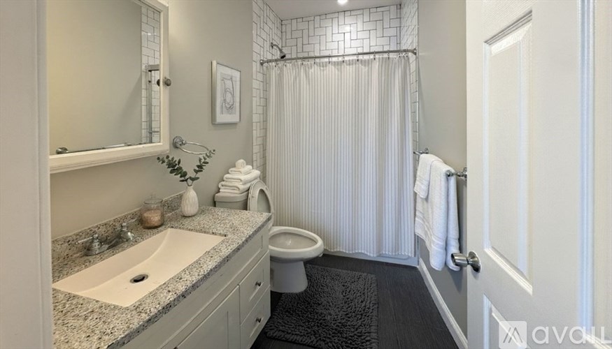 A bathroom with a sink, toilet, and shower.
