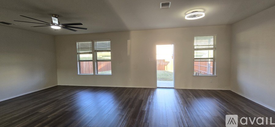 A room with wooden floors and a ceiling fan.