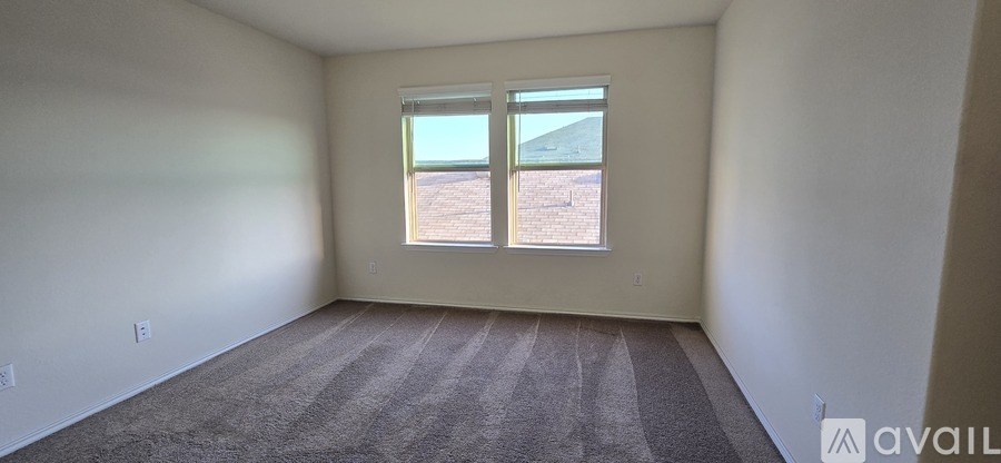 A room with a window overlooking a barren landscape.