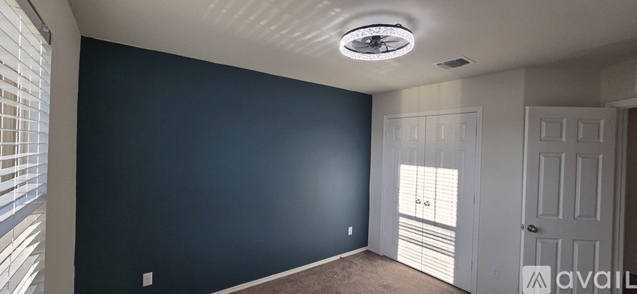 A room with a ceiling fan and a window with blinds.