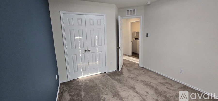 A white door with a glass window is in a room with a carpeted floor.