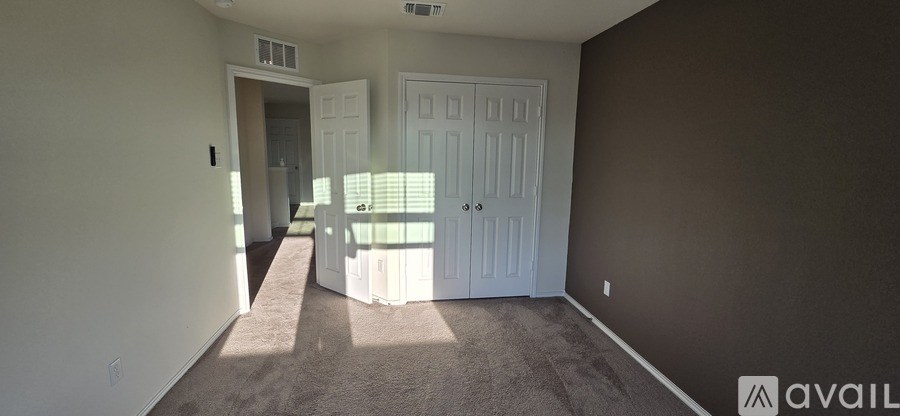 A room with brown walls and carpeting, and a white door.