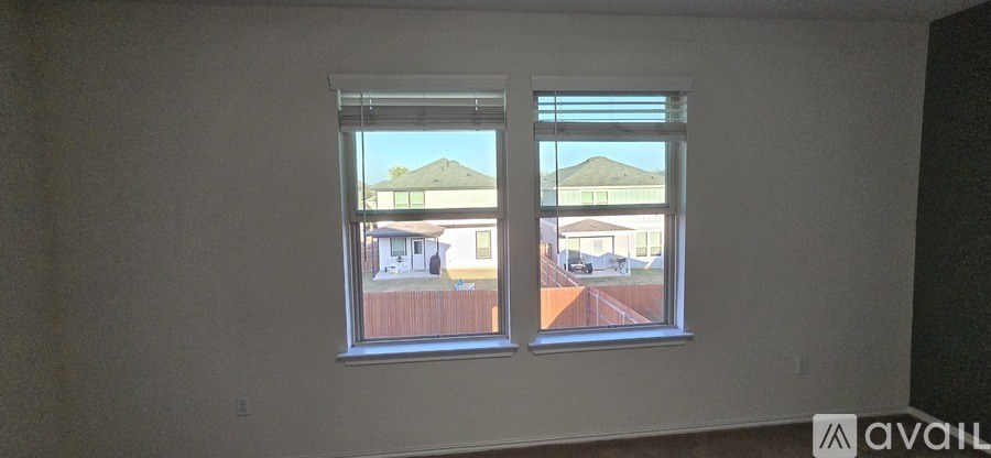 A window with a view of a house and a fence.