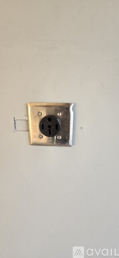 A wall socket with a plug inserted into it.