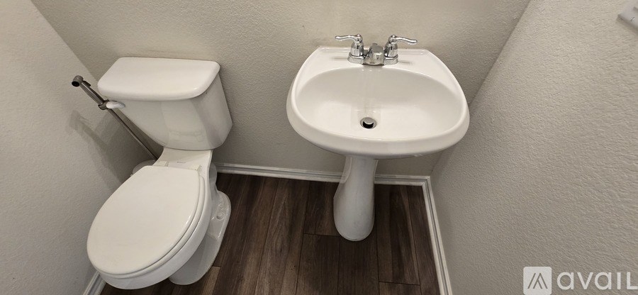 A white toilet and sink in a small bathroom.