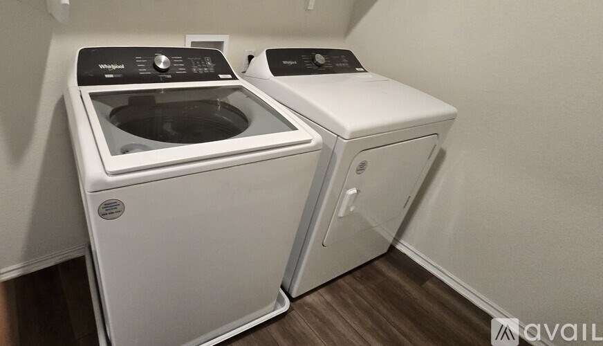 Two white front loading washing machines in a laundry room.