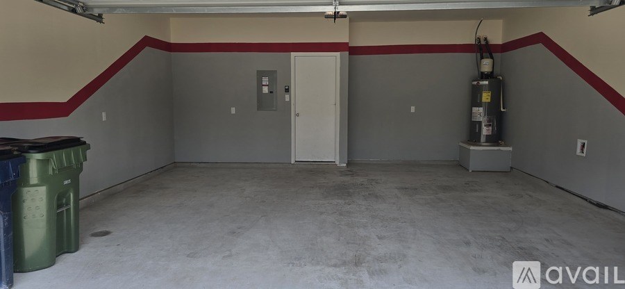 A spacious garage with a white door and a red stripe on the wall.
