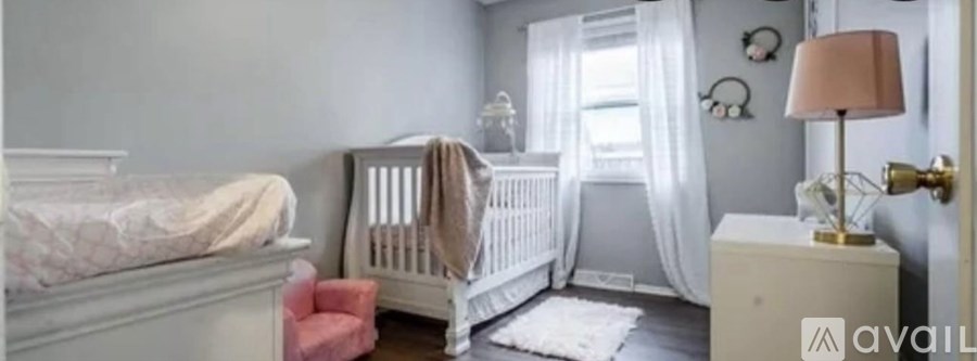 A baby nursery with a white crib and a white changing table.
