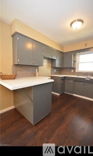A kitchen with a white countertop and grey cabinets.