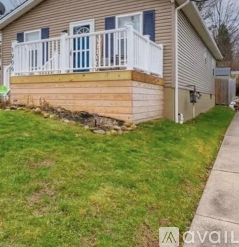 A house with a white porch and a brown roof.