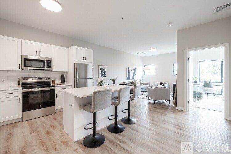 A kitchen with a white island and a dining table with chairs.