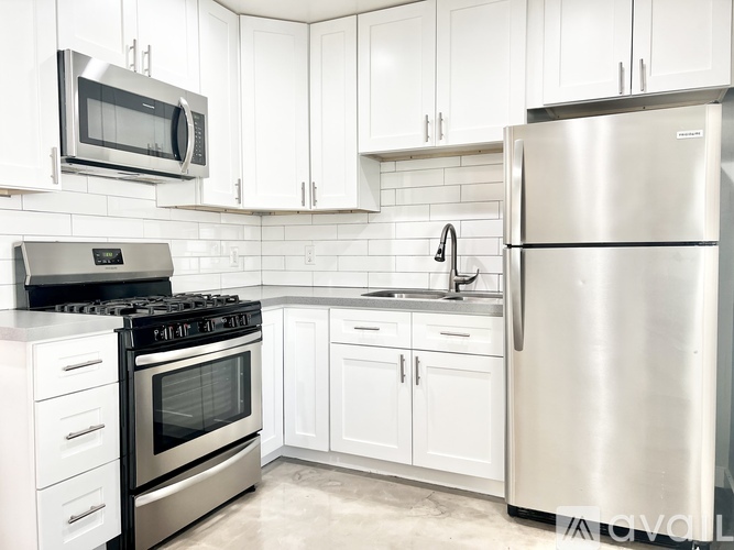 A modern kitchen with white cabinets and stainless steel appliances.