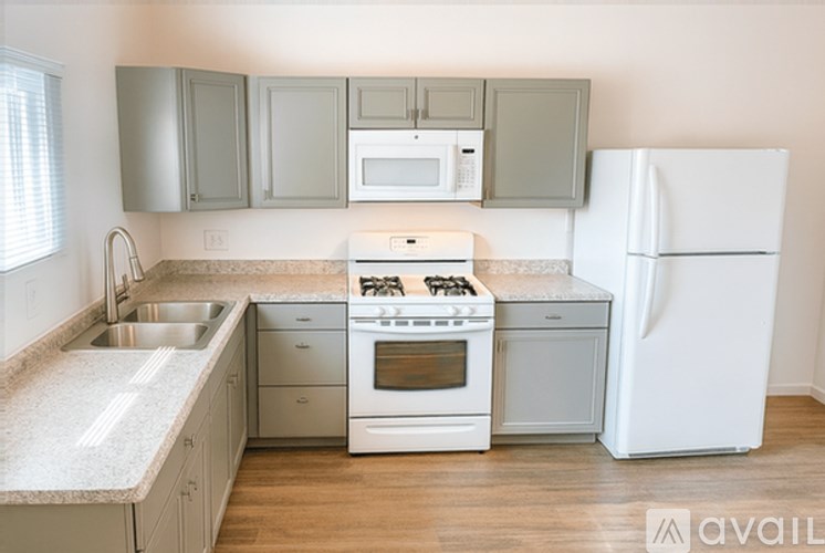 A kitchen with a white refrigerator, stove, and oven.