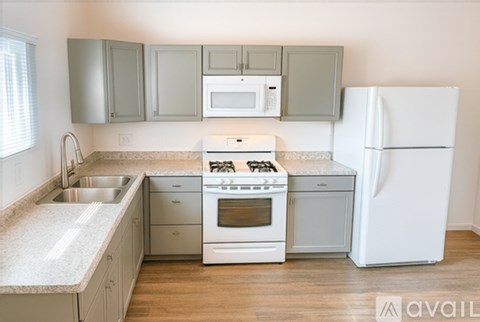A kitchen with a white refrigerator, stove, and oven.