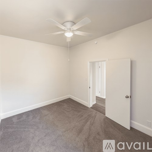 A room with a ceiling fan and carpeted floor.