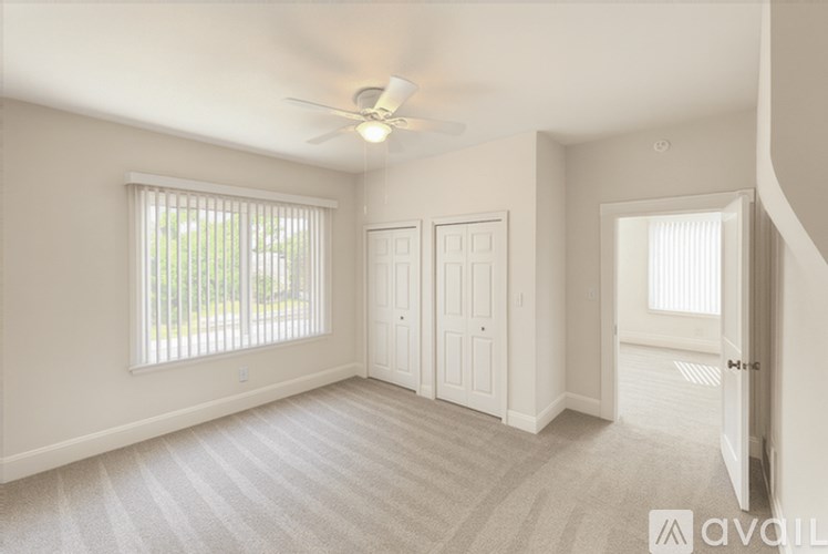 A room with a ceiling fan and two doors.