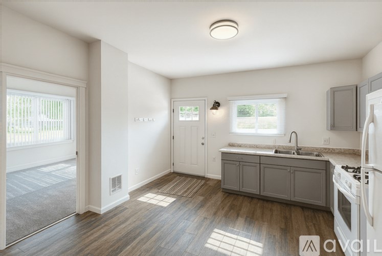 A kitchen with a white fridge, sink, and cabinets.