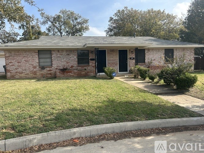A brick house with a black door and windows.