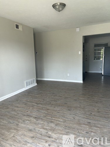 A room with wooden flooring and a door on the right.