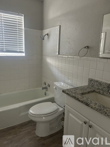 A white toilet in a bathroom with a marble counter.