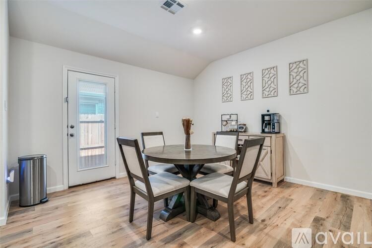 A dining room with a table and chairs.