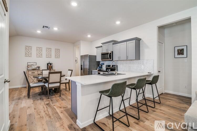 A kitchen with a white counter and bar stools.