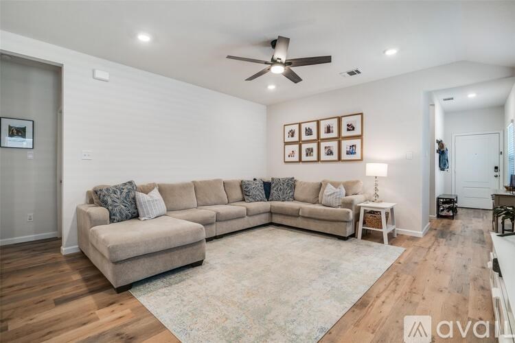 A living room with a large sectional sofa and a rug.