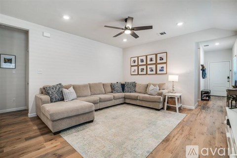 A living room with a large sectional sofa and a rug.