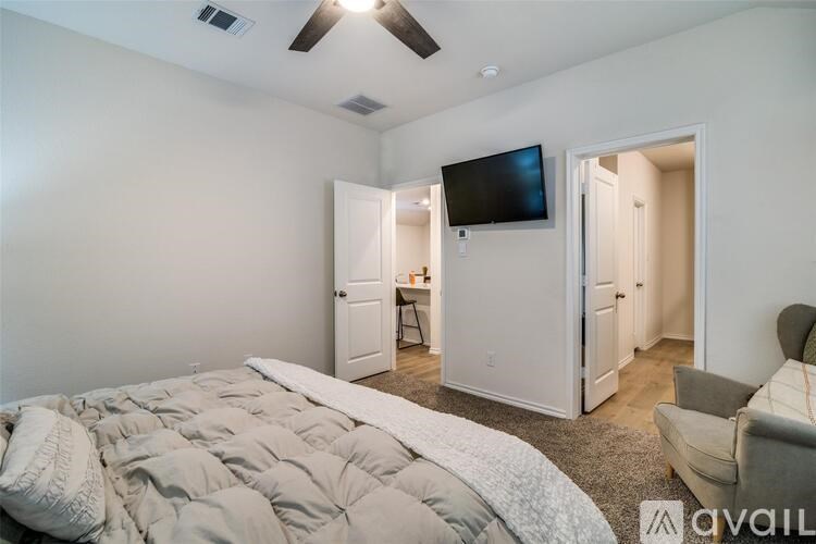 A bedroom with a bed, a couch, and a television.