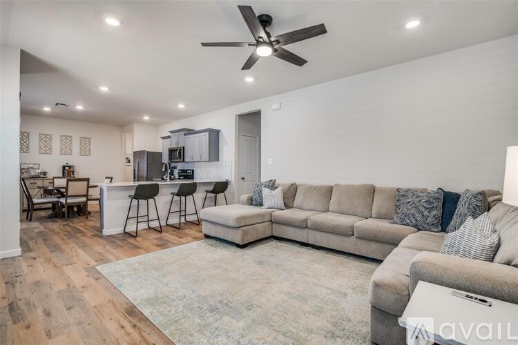 A living room with a large couch and a ceiling fan.