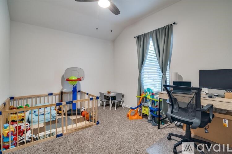 A room with a baby crib, a desk, and a chair.