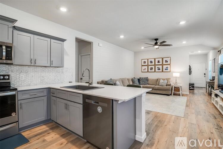 A modern kitchen with wooden floors and a large island.