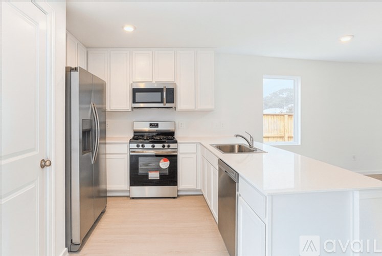 A kitchen with white cabinets and appliances.
