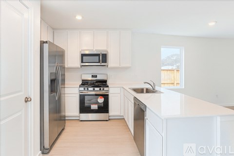 A kitchen with white cabinets and appliances.