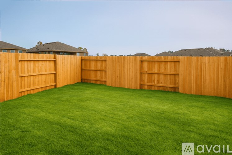 A backyard with a wooden fence and green grass.