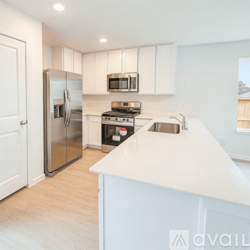A kitchen with white cabinets and a white island.