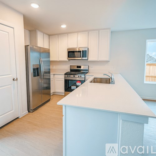 A kitchen with white cabinets and a white countertop.