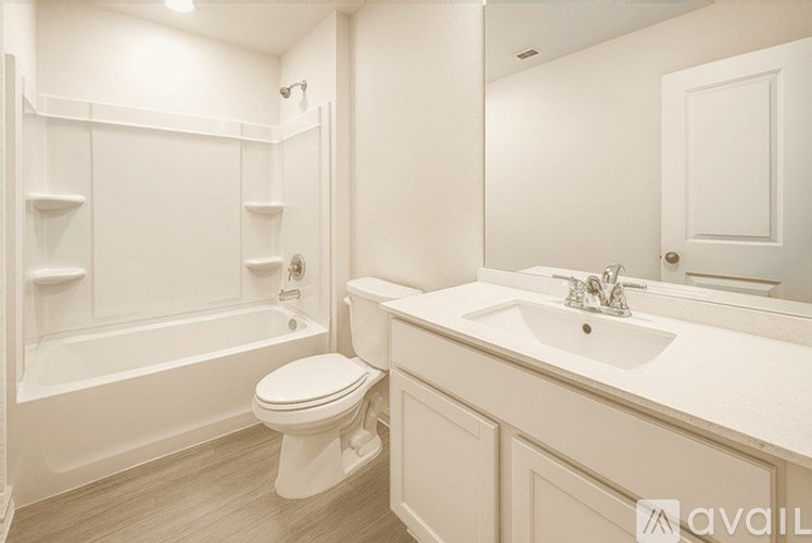 A white bathroom with a toilet, sink, and bathtub.