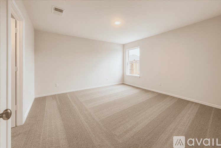 A room with a carpeted floor and a door on the left side.