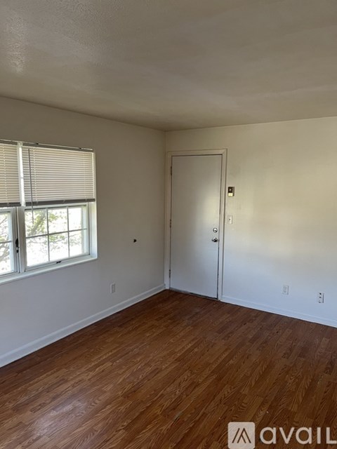 A room with wooden floors and a white door.