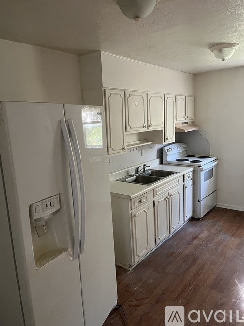 A kitchen with a white refrigerator and wooden cabinets.
