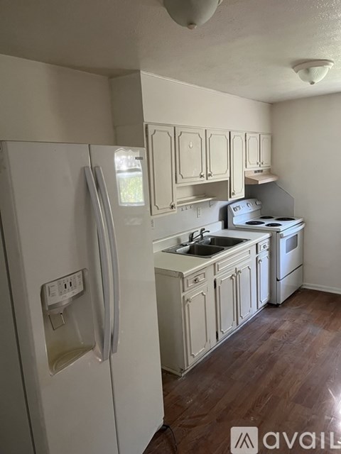 A kitchen with a white refrigerator and wooden cabinets.