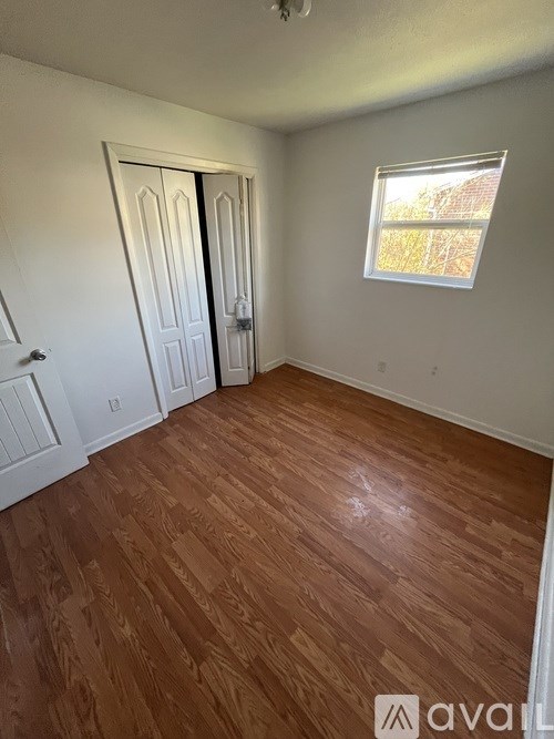 A room with wooden flooring and a window.