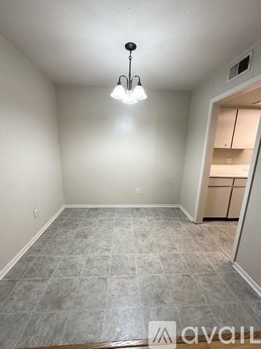 A room with tile flooring and a hanging light fixture.