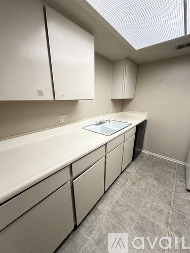 A kitchen with white cabinets and a countertop.