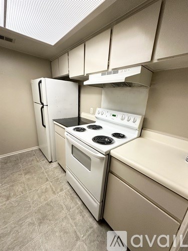 A kitchen with a white fridge, stove, and oven.