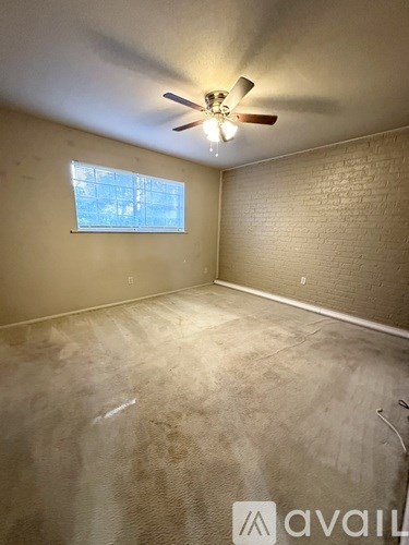 A room with a ceiling fan and a window.