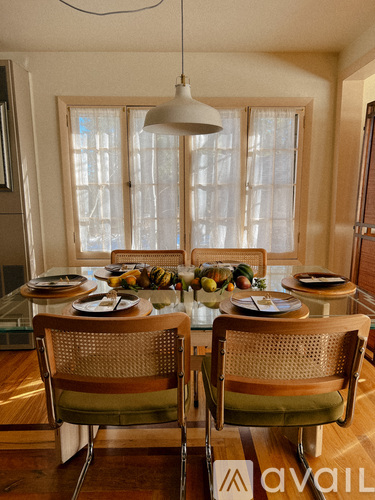 A dining room with a table set for two and a fruit bowl on the table.