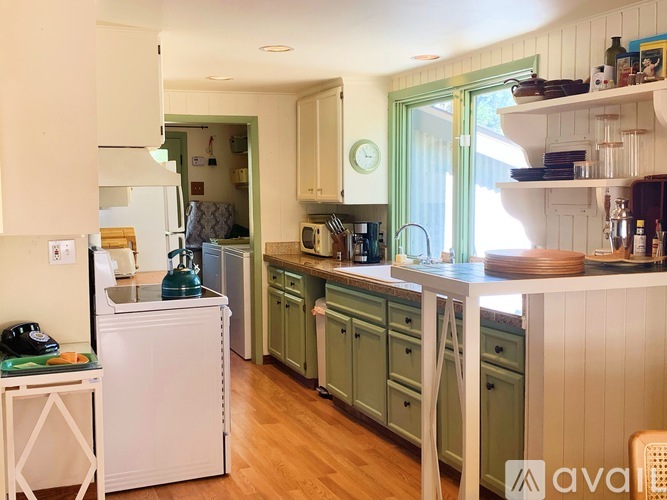 A kitchen with white cabinets and green drawers.