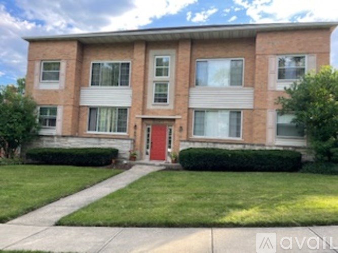 A brick building with a red door and windows.